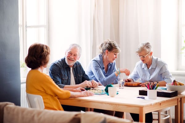 Residents enjoying a game together in a bright activity room
