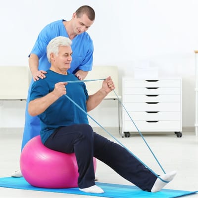 A staff member assisting a resident with exercise