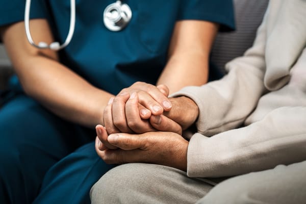 A caregiver holding hands with a resident