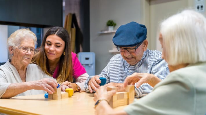 Residents engaging in a cognitive activity with staff assistance
