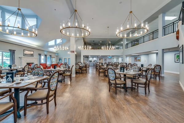 Bright dining room with elegant chandeliers and seating.