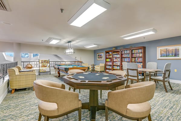 Bright common area with game tables and bookshelves