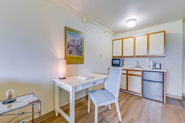 A well-furnished resident room with a kitchenette