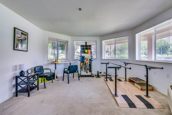 An interior room with exercise equipment for rehabilitation