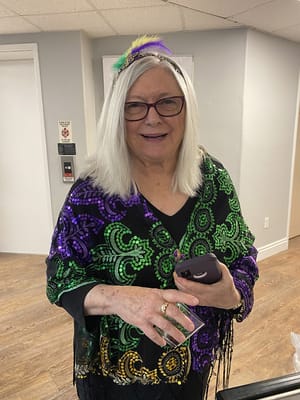 Resident dressed for a festive event with a phone in hand
