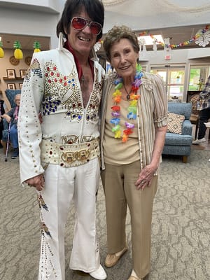 Residents celebrating with an Elvis impersonator in a common area