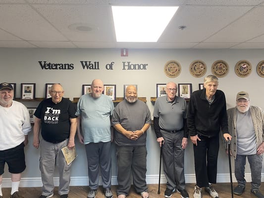 Residents standing in front of the Veterans Wall of Honor
