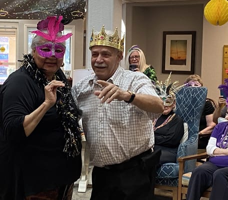 Residents celebrating with masks and crowns in a common area