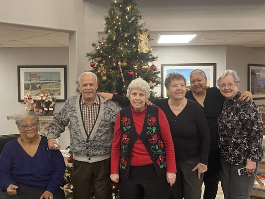 Residents posing together by a decorated Christmas tree