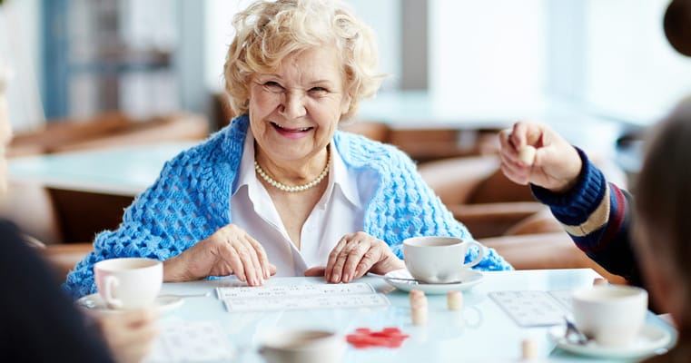 A senior woman enjoying bingo with coffee