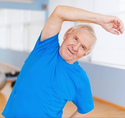Senior man stretching in an activity room