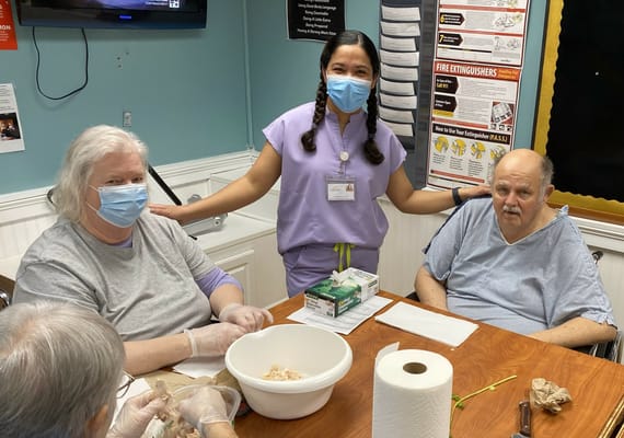 Residents engaging in an activity with staff assistance