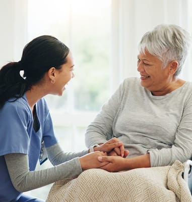 Nurse and resident laughing together in a bright room