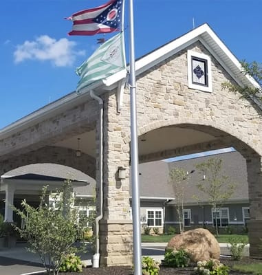 Entrance of the facility with flags and stone architecture