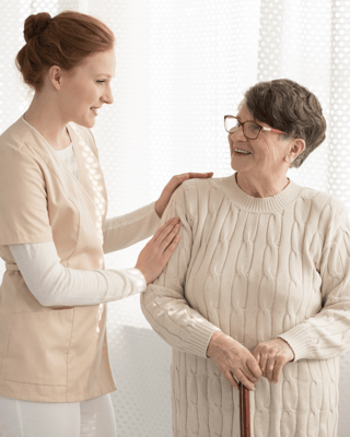 Staff assisting a resident in a bright indoor setting