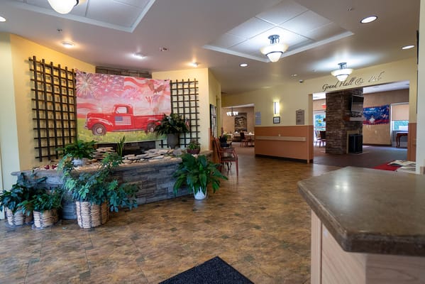 Bright lobby area with a colorful mural and plants