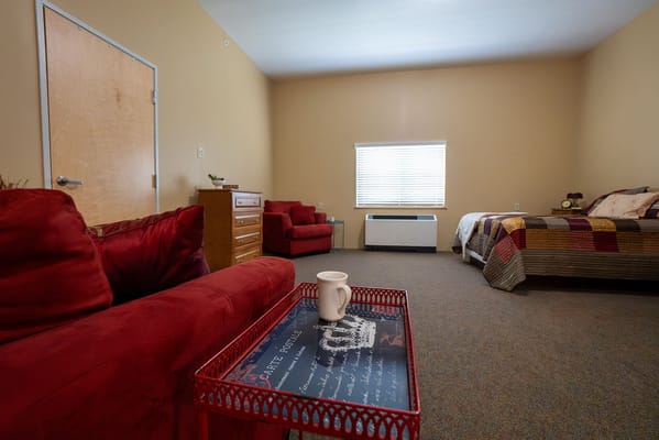 A cozy private room with seating and a bed