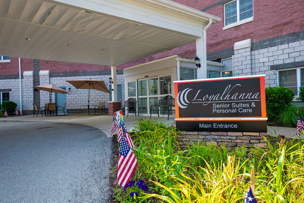 Building entrance of Loyalhanna Senior Suites with flags