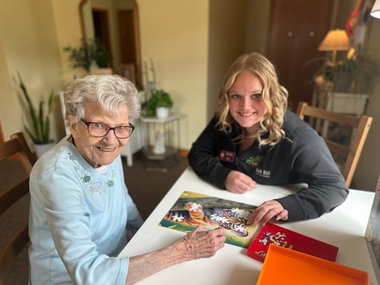Resident and staff member enjoying a puzzle activity together