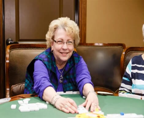 Resident playing dominoes in an activity room