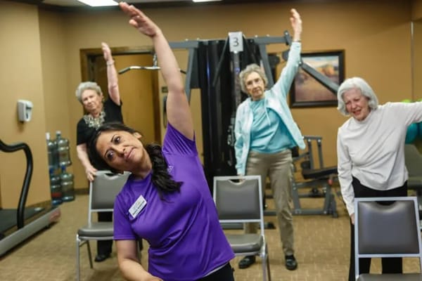 Residents participating in an exercise class with staff guidance
