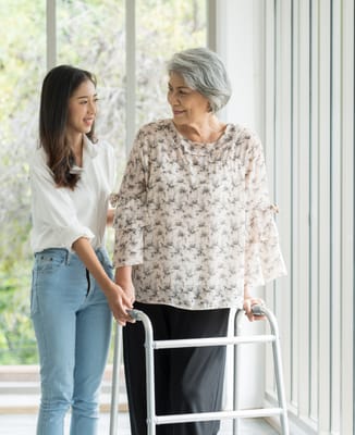 Staff assisting a resident indoors with a walker