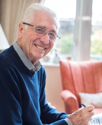 Senior resident smiling while engaging in an activity