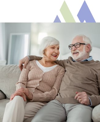 A happy elderly couple sitting on a couch
