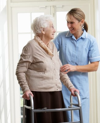 Caregiver assisting a resident with a walker indoors