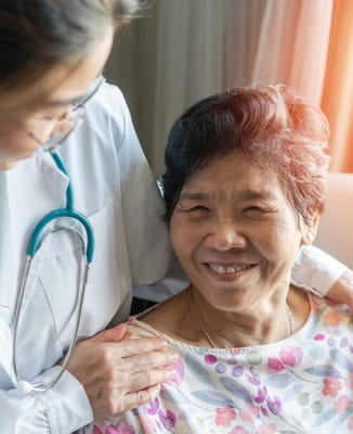 A nurse interacting with a smiling senior resident