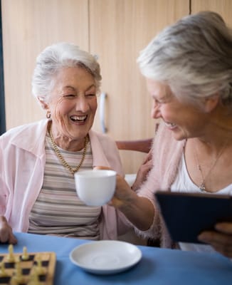 Two senior women enjoying tea and conversation