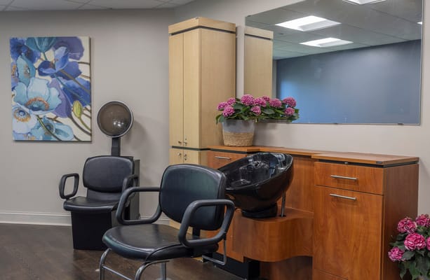 Hair salon area with styling chairs and flowers