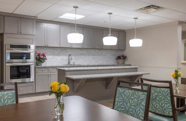 Bright common area with a kitchen and flowers on tables