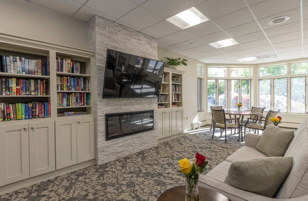 Cozy common area with bookshelves and a fireplace