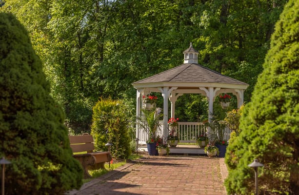A gazebo surrounded by lush greenery and flowers