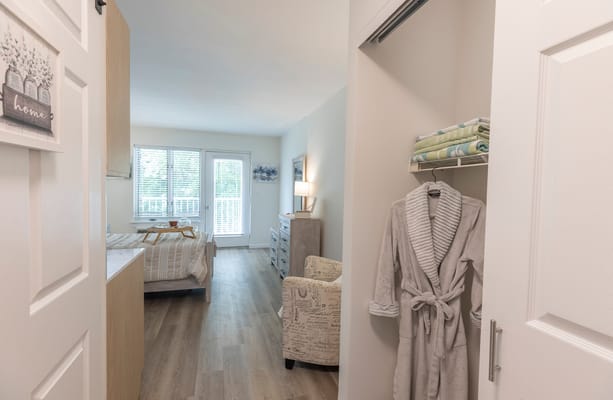 Bright interior of a resident room with a bed and chair