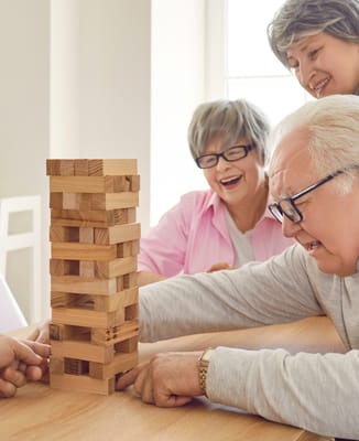 Residents enjoying a game of Jenga at a sunny table