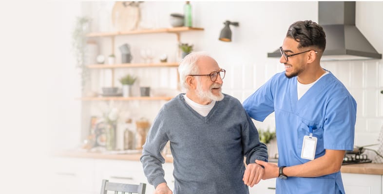 Caregiver assisting a smiling senior in a modern kitchen