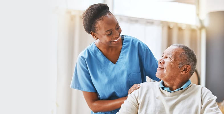 A caregiver interacting with a resident in a bright room