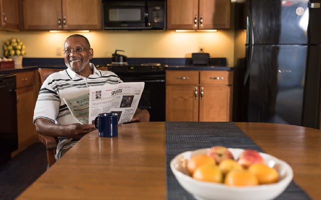 Senior resident enjoying a newspaper in the kitchen