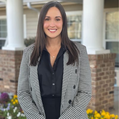 Staff member posing in front of the facility