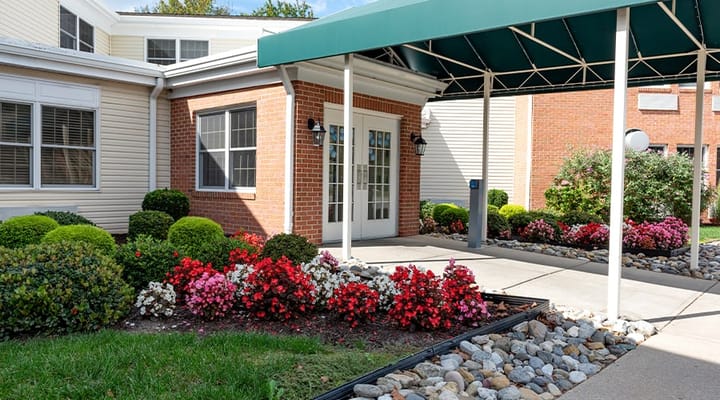 Exterior view of facility entrance with landscaped flowers