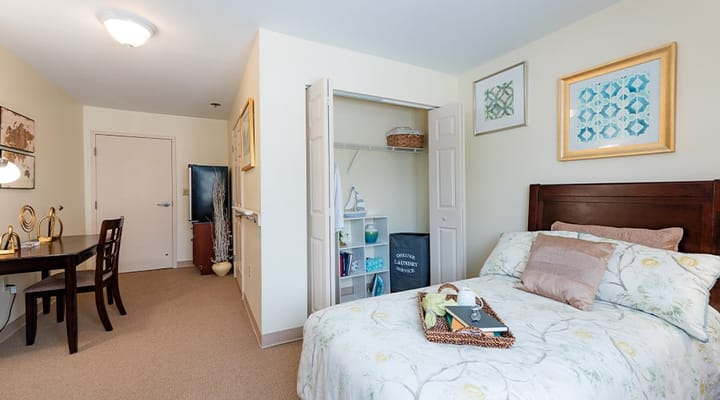 A cozy resident room showing a bed and seating area
