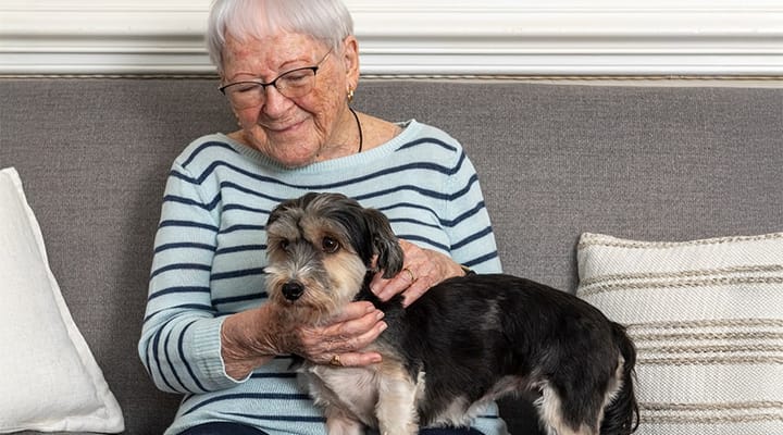 Senior resident with a small dog in a cozy indoor setting