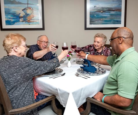 Residents enjoying a toast at the dining table