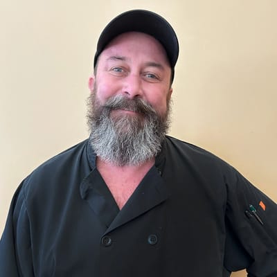 Chef in a kitchen uniform with a friendly smile