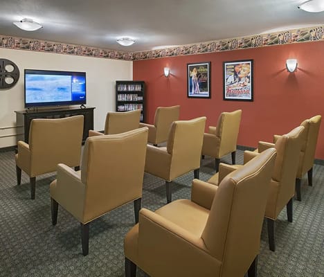 A cozy movie room with seating for residents