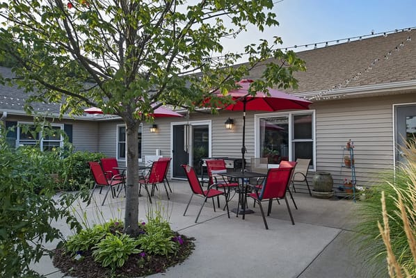Outdoor seating area with red umbrellas and green plants
