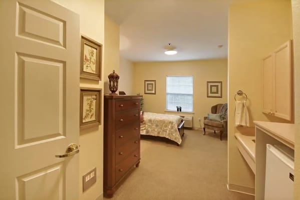 Interior view of a resident room with a bed and dresser