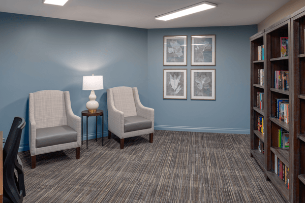 A cozy common area with seating and bookshelves